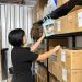 A woman placing a box on the shelf
