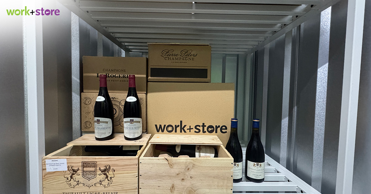 Storage shelf containing wine bottles and cardboard boxes inside a storage unit