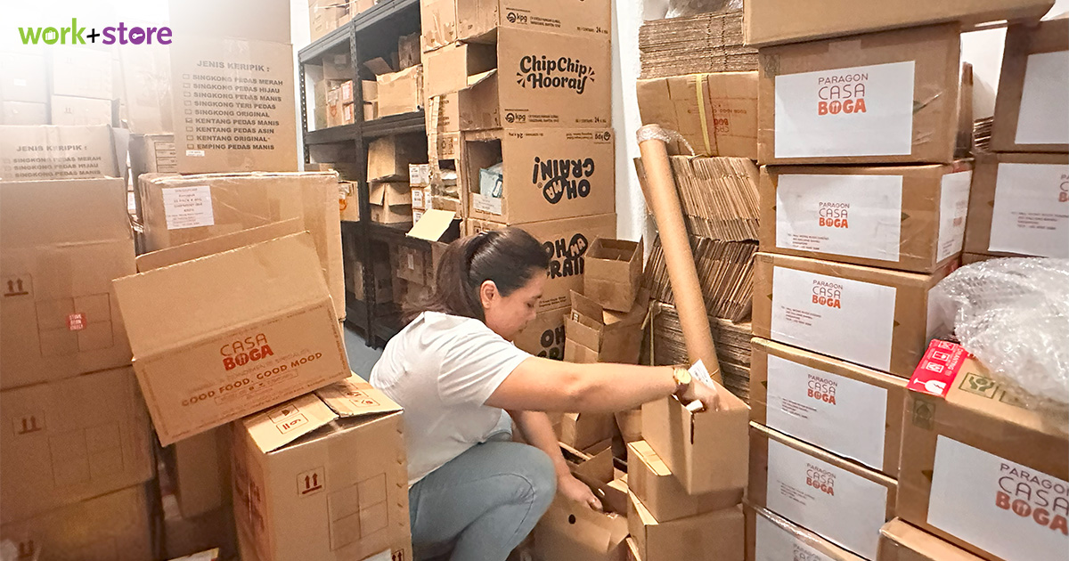 Person organizing cardboard boxes in a storage warehouse space
