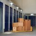 Self Storage Units And Close-up Of Hand Truck With Cardboard Boxes In Corridor