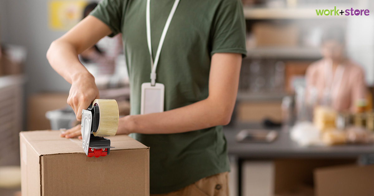 Person taping a cardboard box for event storage packing.